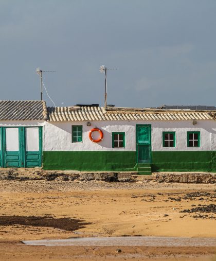 A white and green building in the middle of a field in Fuerteventura, Canary Islands